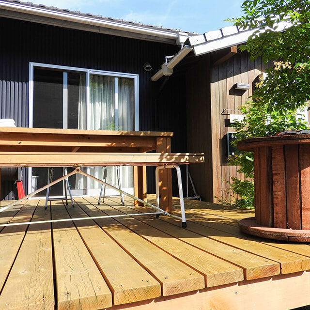 ウッドデッキに設置されたテーブルと椅子、心地よい外構スペース