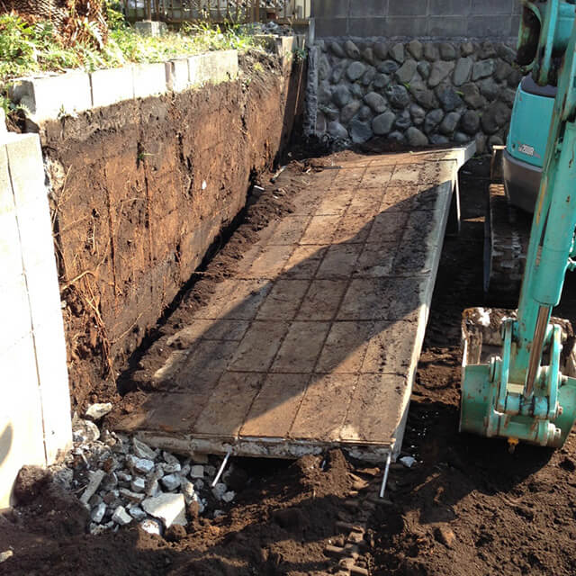 重機でブロック塀を撤去し整地している現場